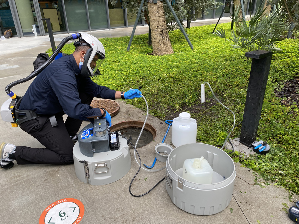 Walter Lamar, executive director of Facilities, Safety and Compliance for the Miller School of Medicine, setting up an autosampler device to collect wastewater outside Lakeside Village on the Coral Gables Campus.